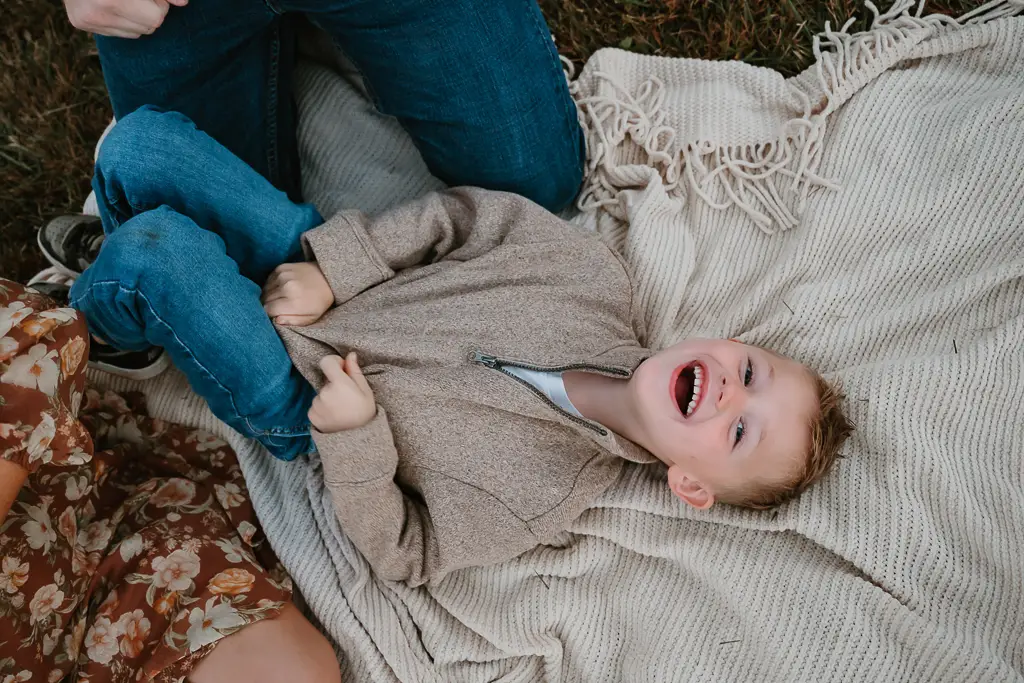 child smiling while lying down during family photo session